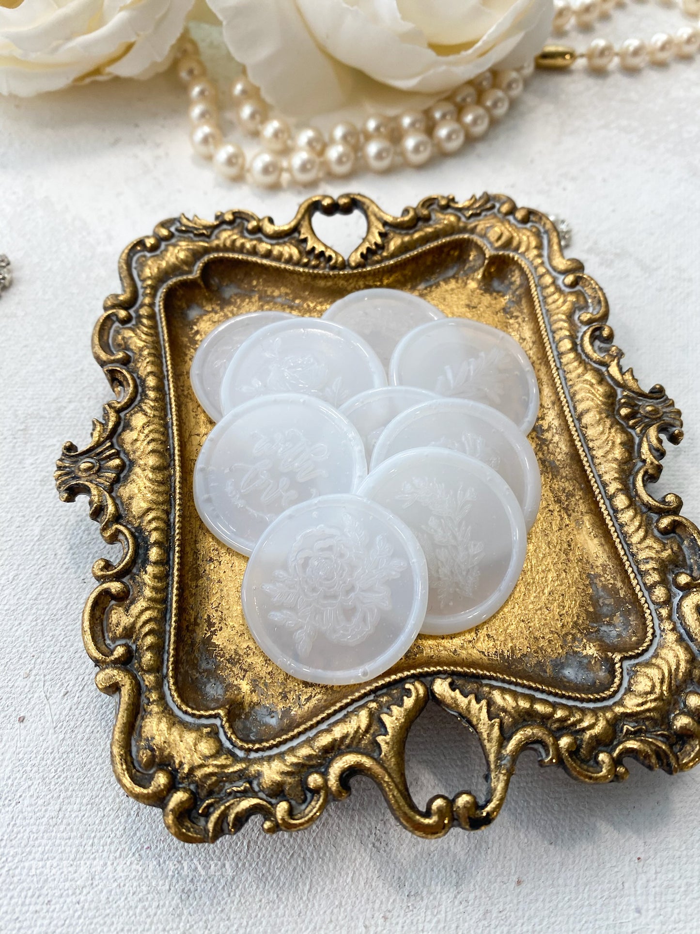 a picture of some white buttons in a gold frame