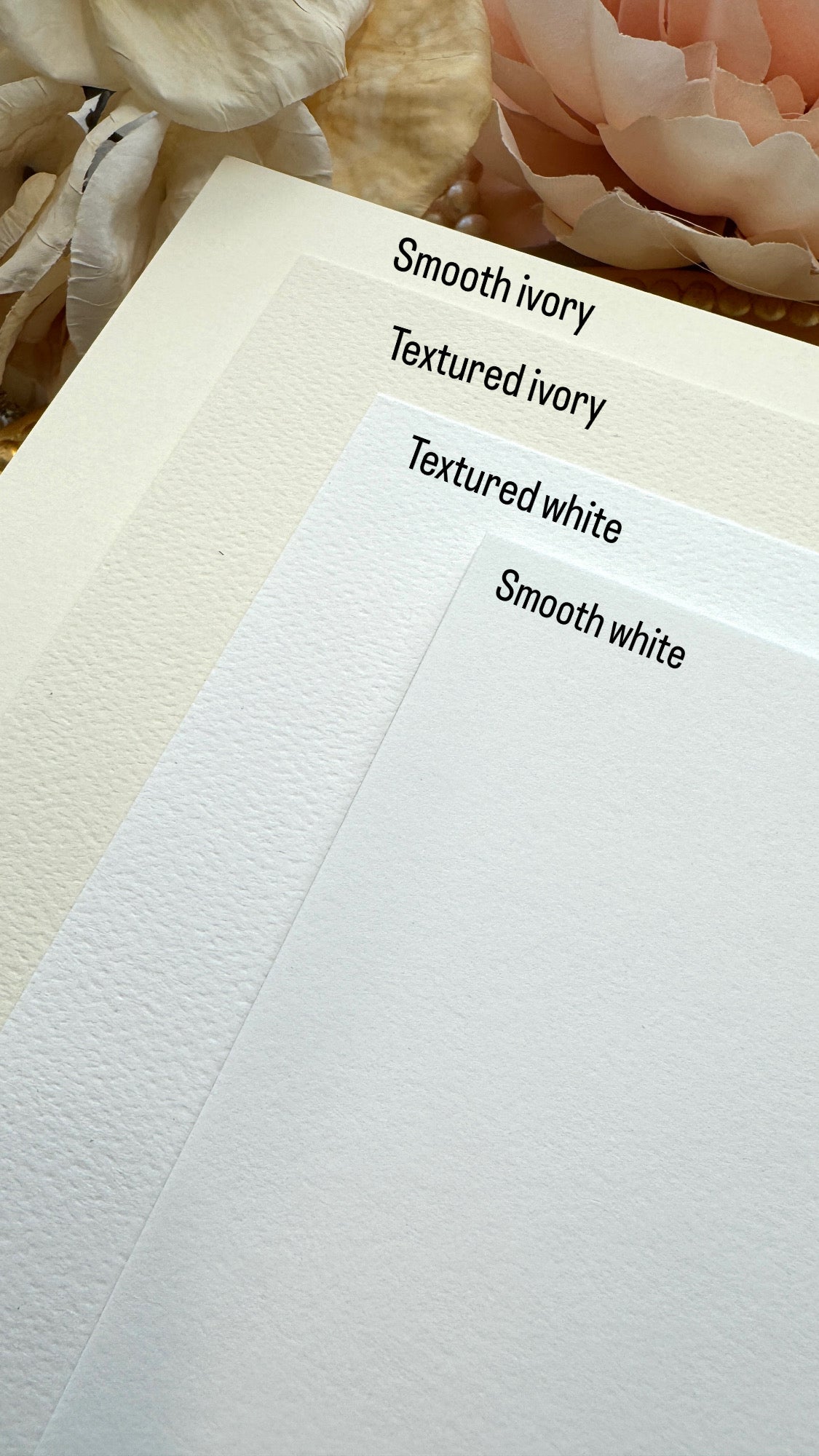 a close up of a piece of paper with flowers in the background
