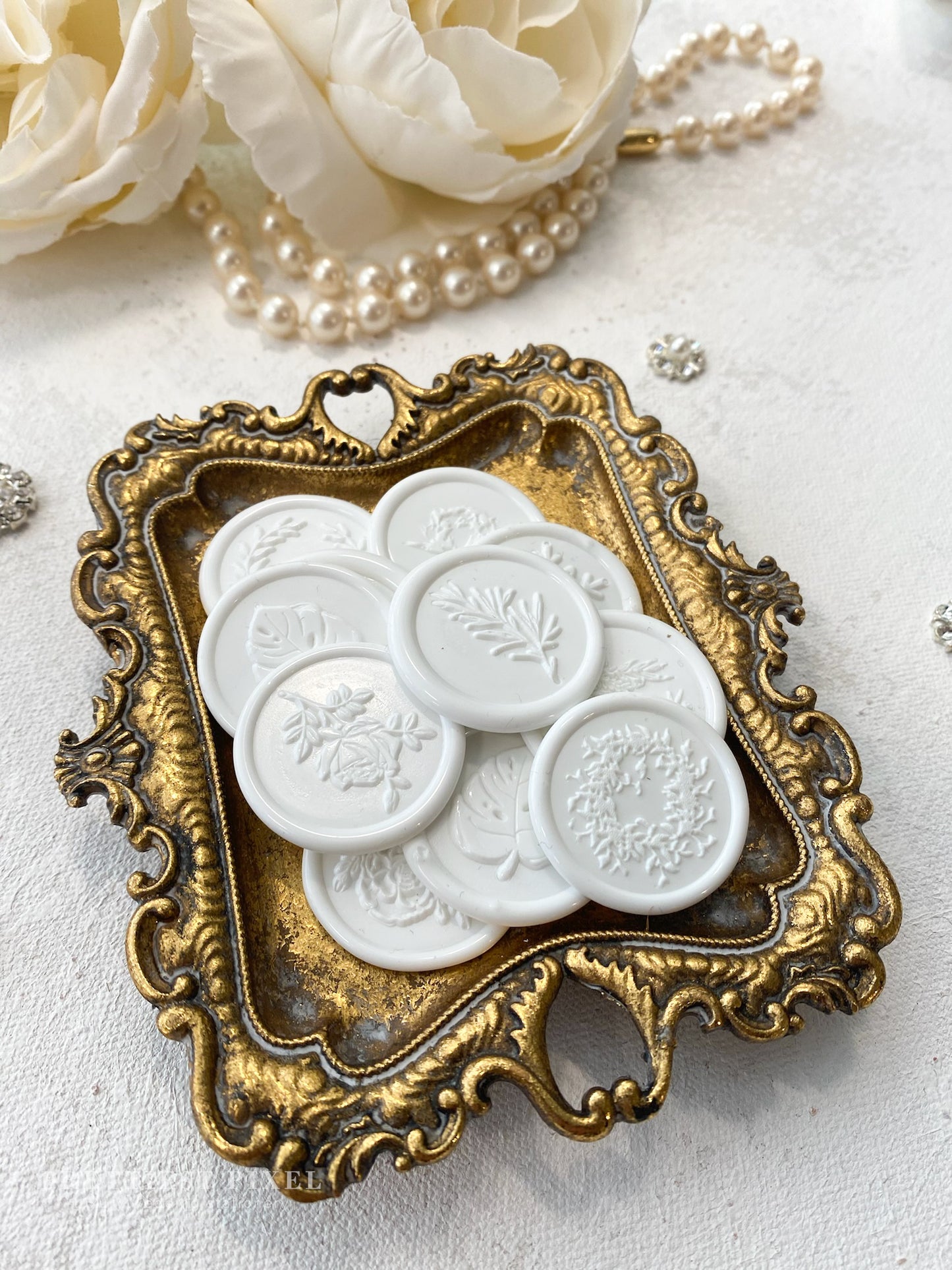 a picture of some white buttons in a gold frame