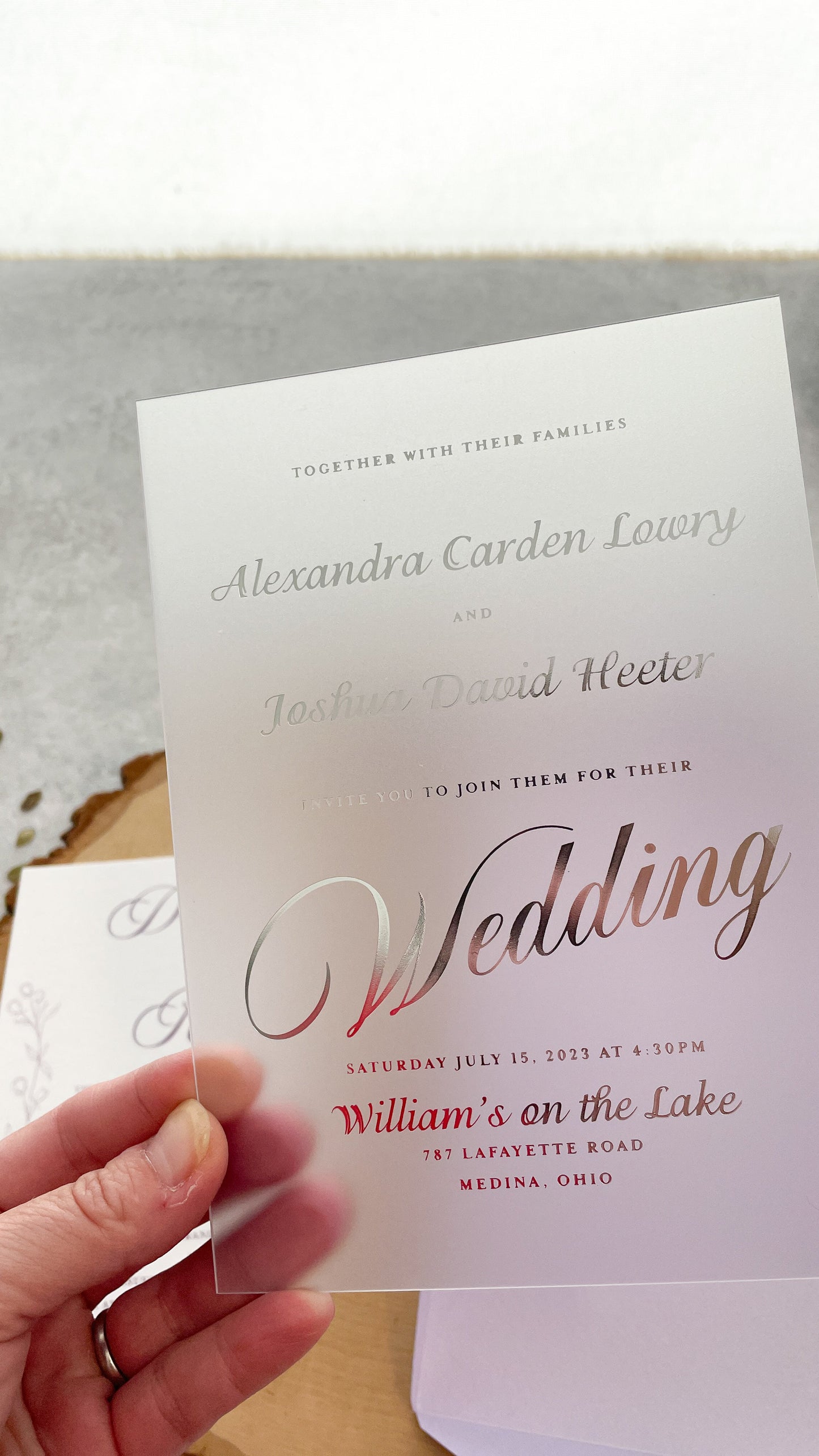 a person holding a wedding card in their hand