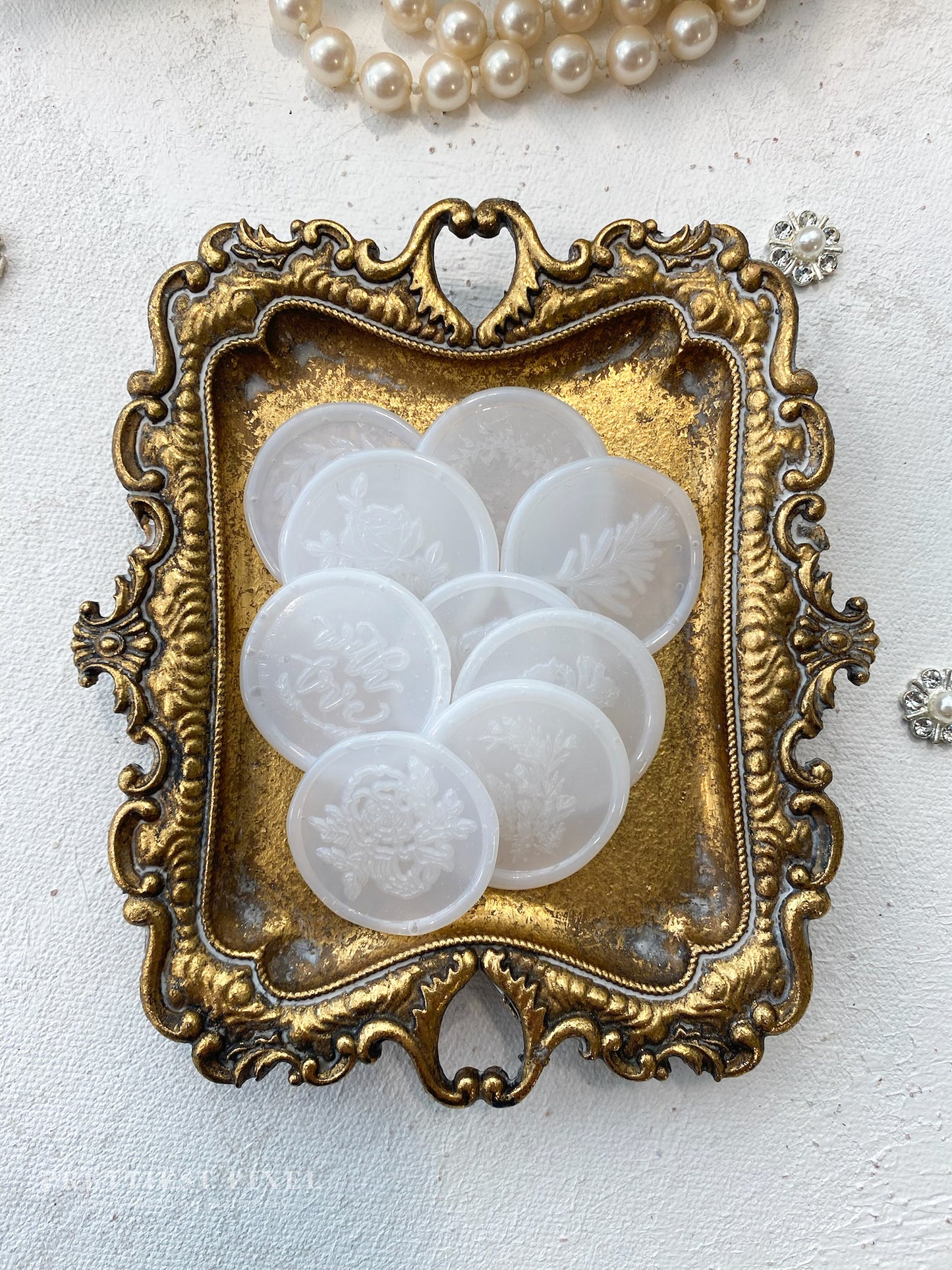 a picture of some white buttons in a gold frame