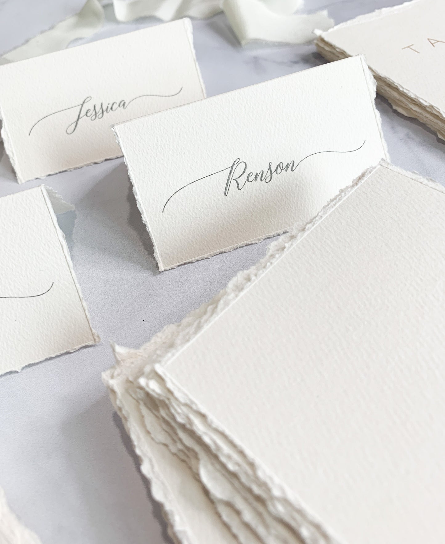 a table topped with lots of white place cards