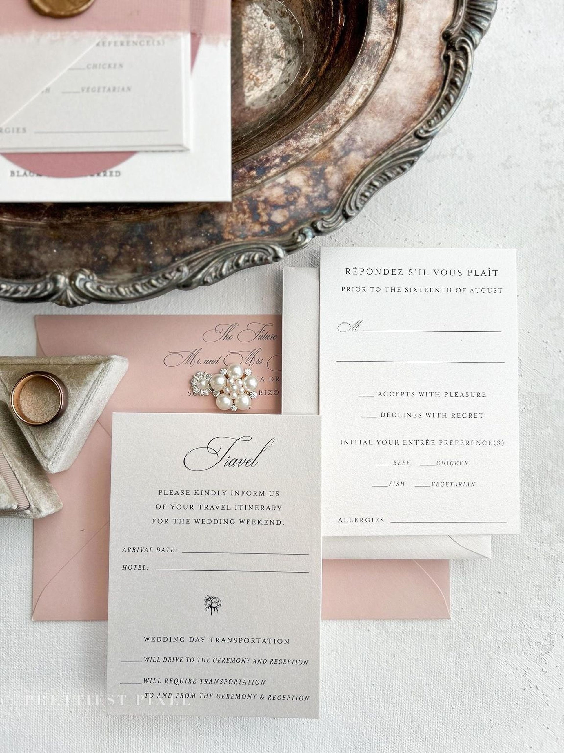 a wedding invitation with a pink and white color scheme, placed on a white surface. The invitation includes details about the wedding ceremony and reception, as well as instructions for guests to RSVP and confirm their attendance.