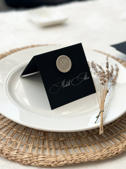 a white plate topped with a black place card