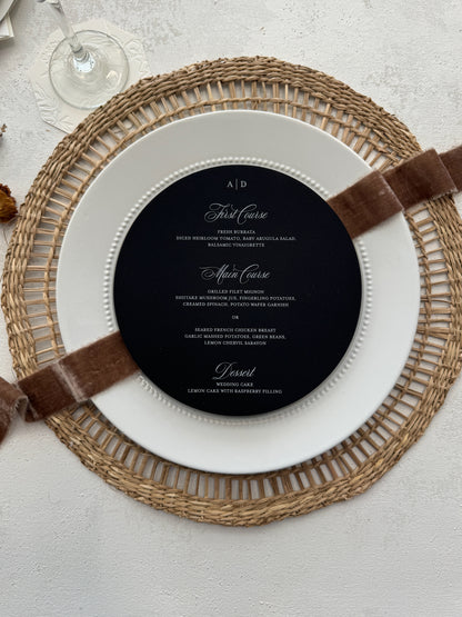 a black and white plate with a brown ribbon around it