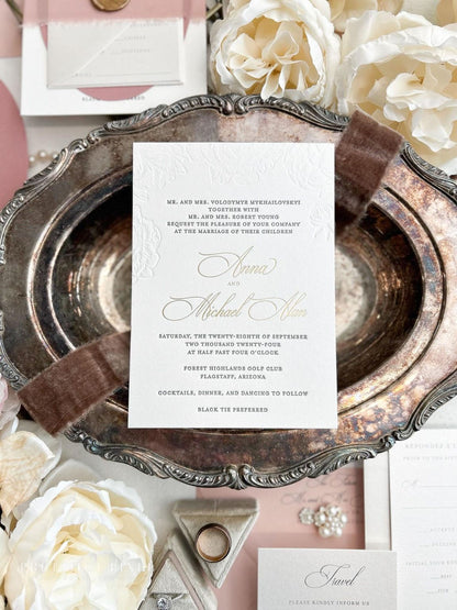 a wedding invitation card with elegant text and designs, surrounded by various wedding-related items such as flowers, a silver tray, and other decorative elements.