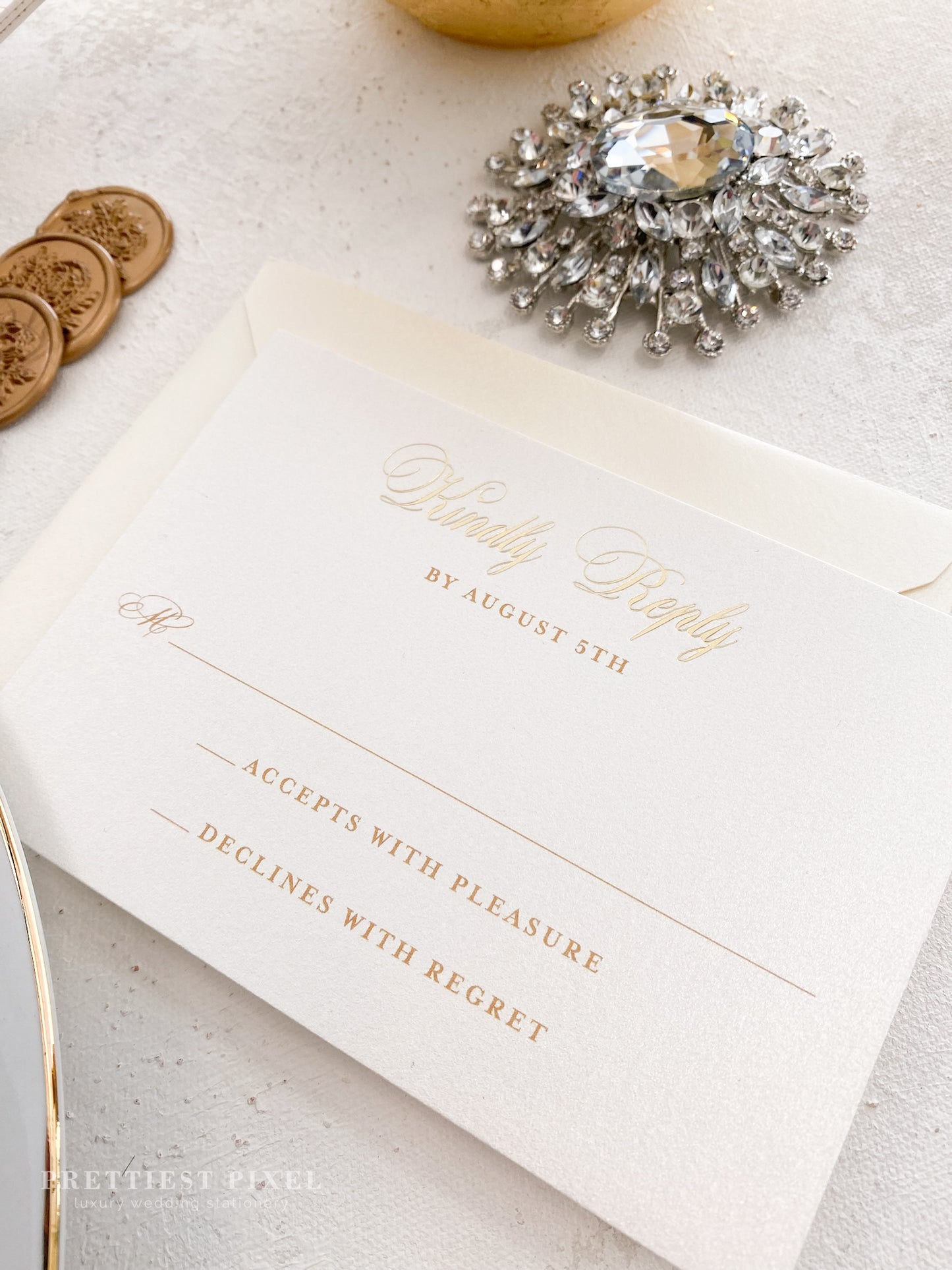 a table topped with a white and gold wedding card