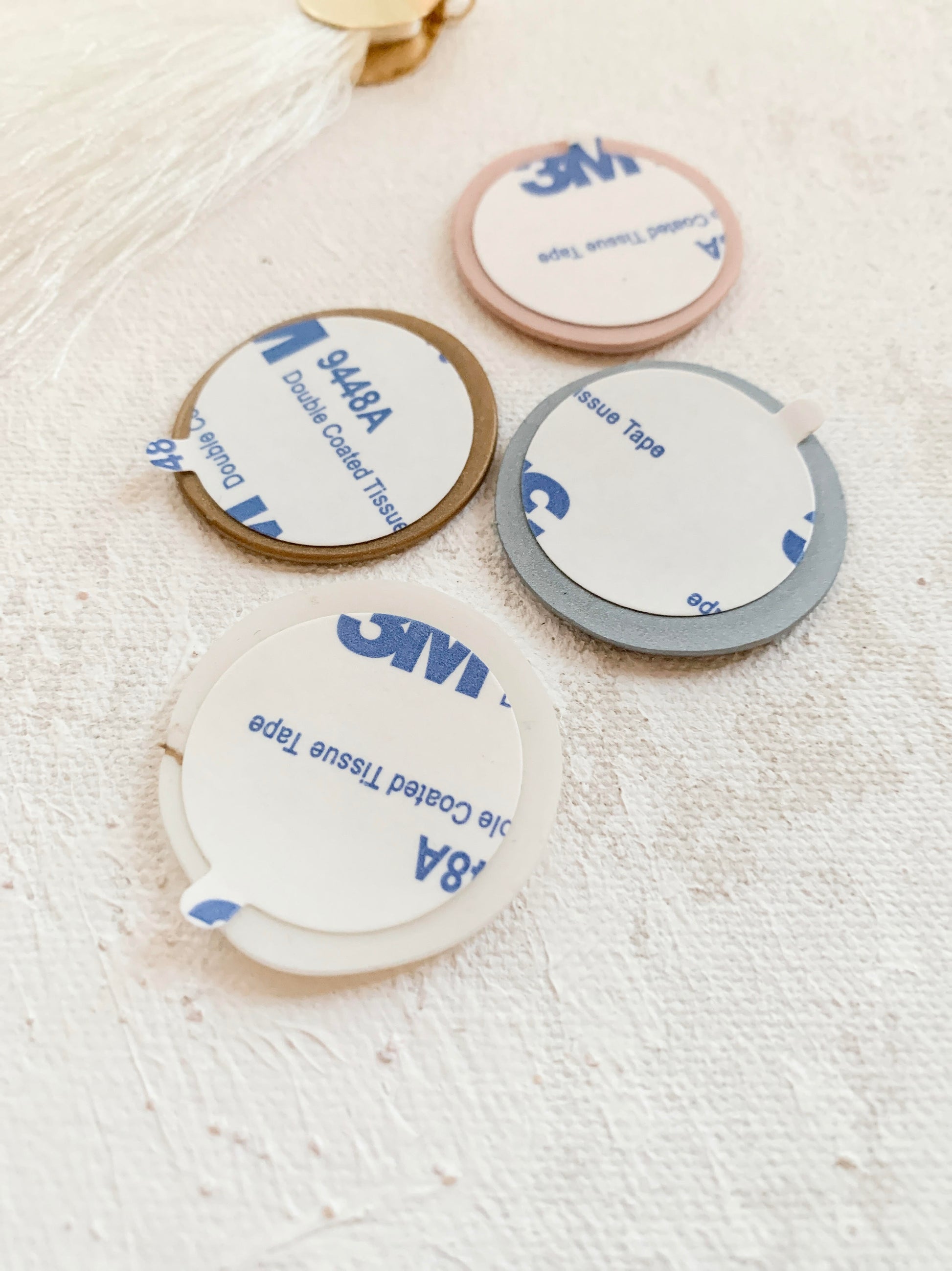 a group of three white and blue coasters sitting on top of a table