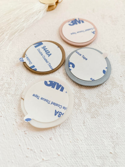 a group of three white and blue coasters sitting on top of a table