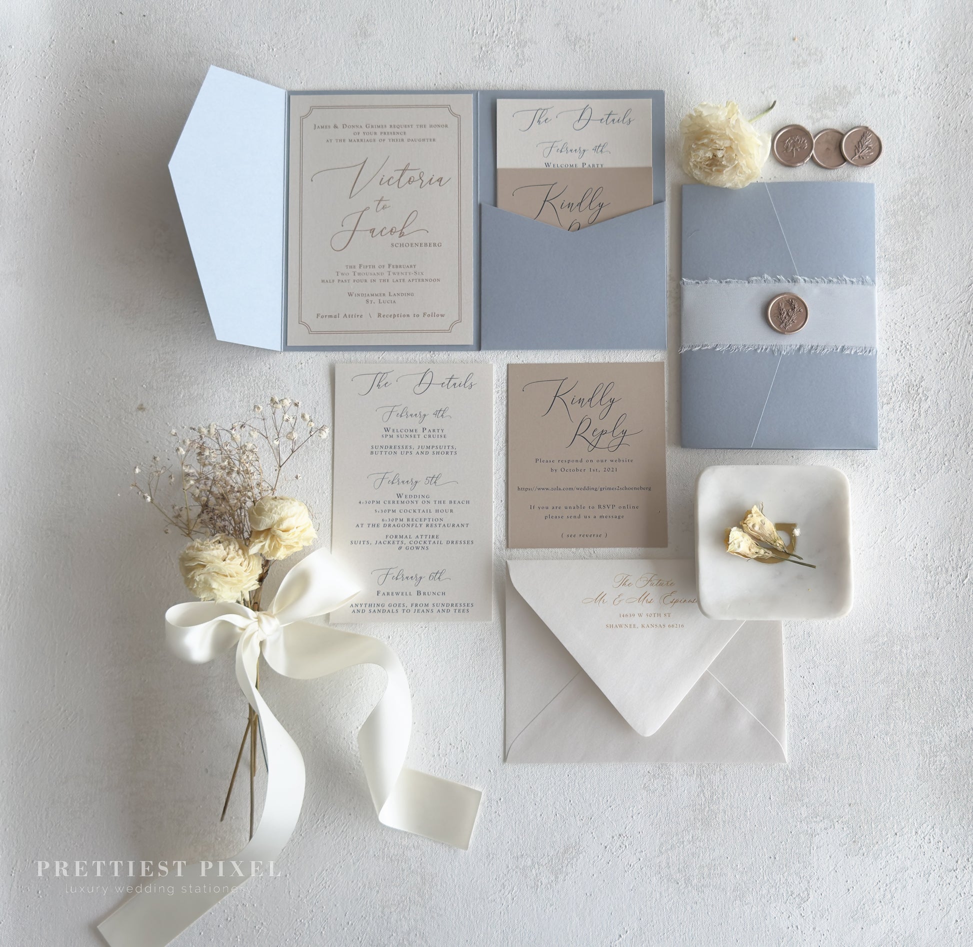 wedding stationery items, including an invitation, envelopes, and a small floral arrangement, all arranged on a white background.