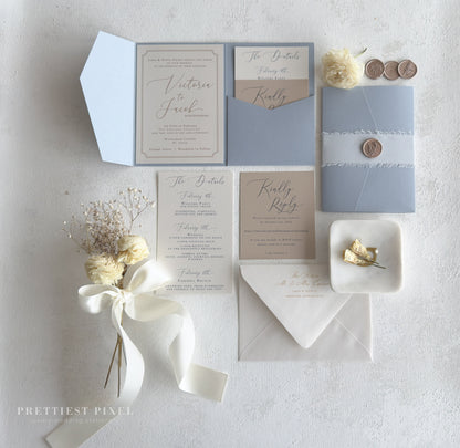 wedding stationery items, including an invitation, envelopes, and a small floral arrangement, all arranged on a white background.