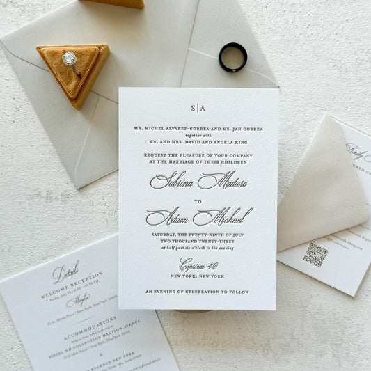 Wedding invitation card with envelope and decorative items on a light surface