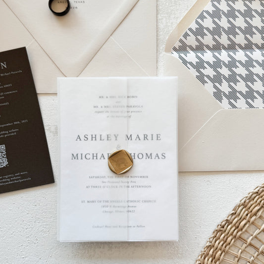 Wedding invitation with ring and stationery on a textured surface