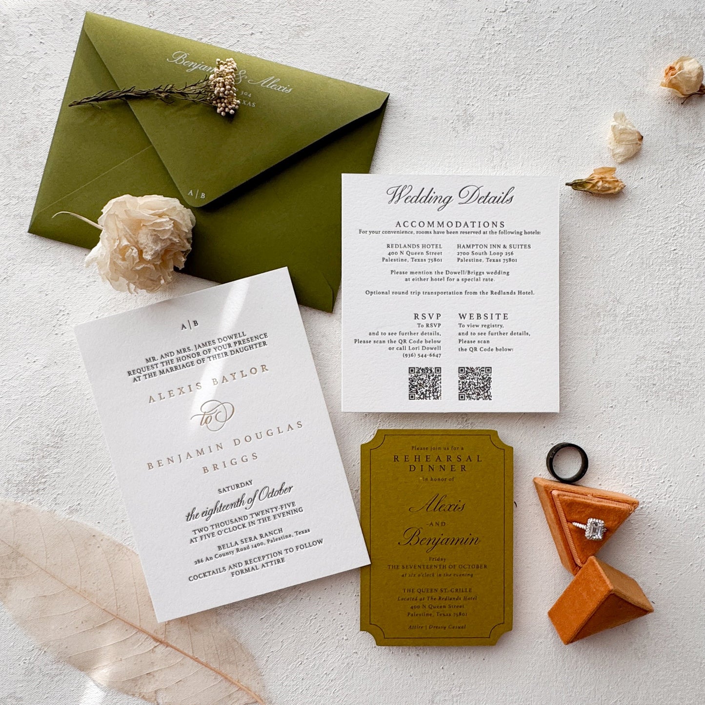 Wedding invitation set with green envelope and cards on a light surface.