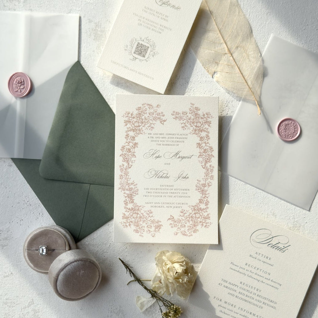 Wedding invitation set with envelopes and decorative elements on a light surface