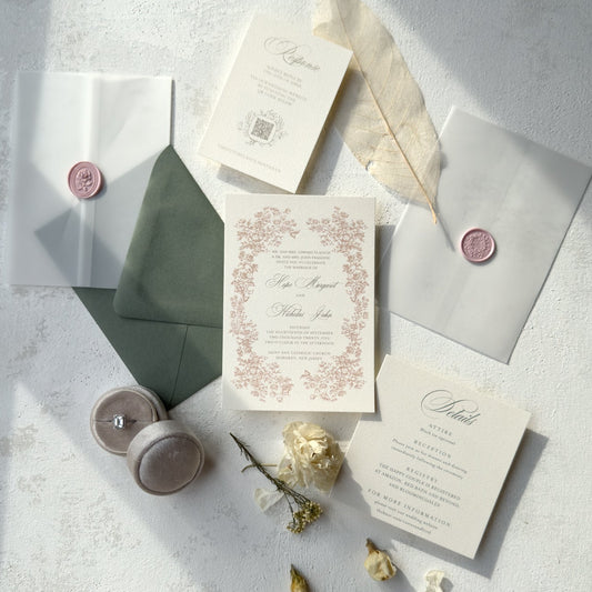 Wedding invitation set with envelopes and decorative elements on a light surface