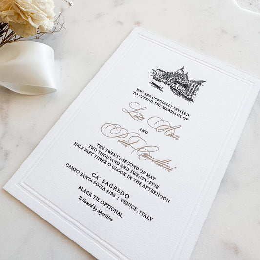 Wedding invitation card on a marble surface with flowers