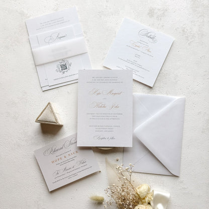 Wedding invitation set with envelope, card, and decorative elements on a light background