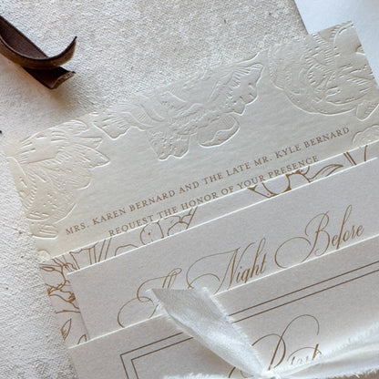 Elegant wedding invitation suite with a white ribbon on a textured surface