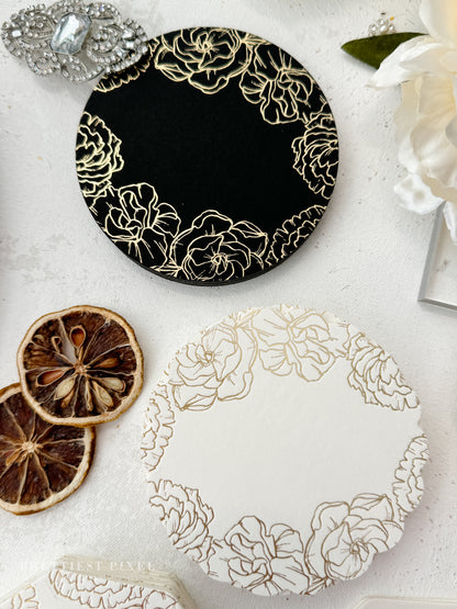 a white table topped with a black and gold plate