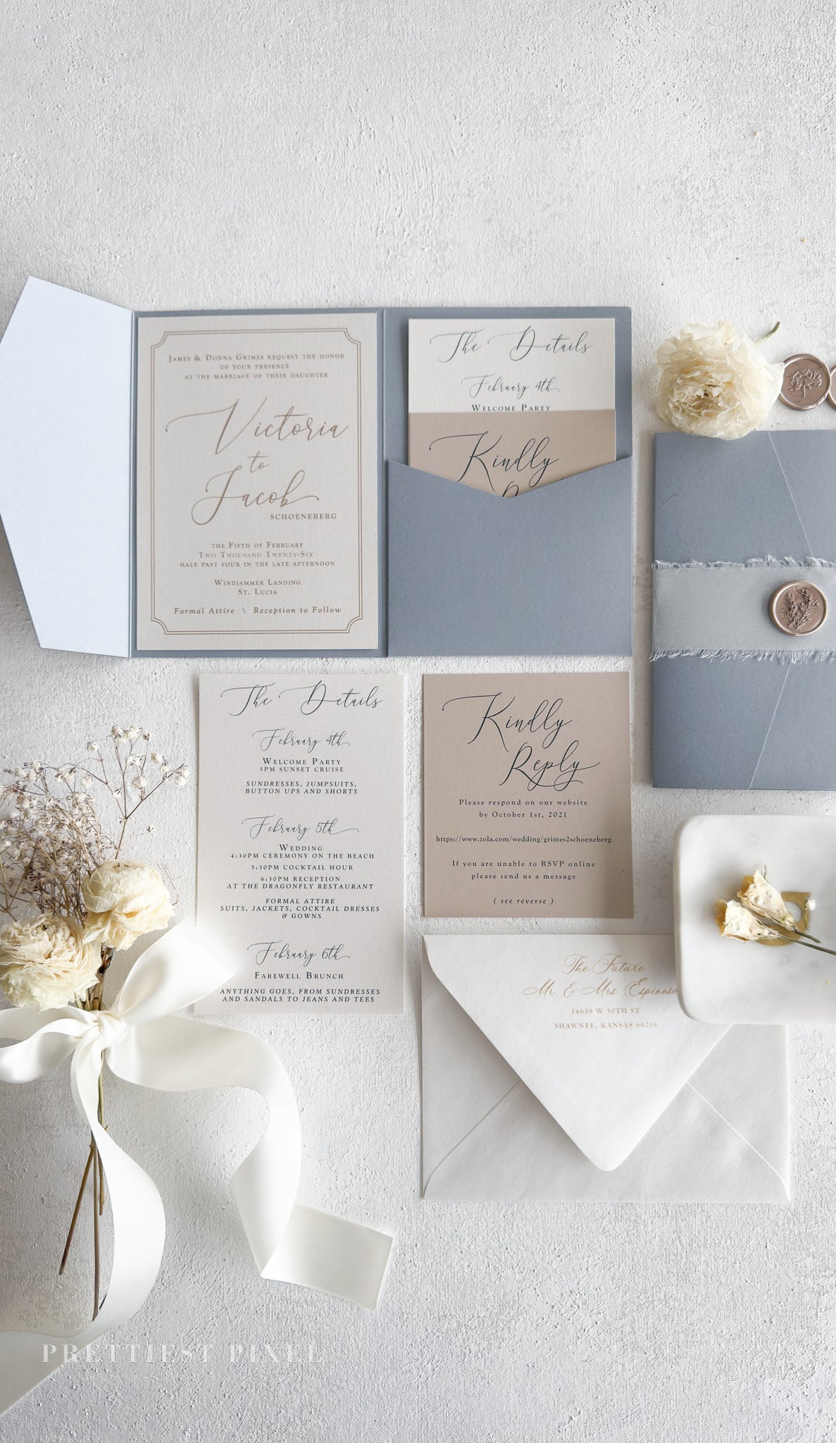 a collection of wedding-related items, including an invitation, a response card, and some decorative elements such as a vase with flowers and a ribbon.