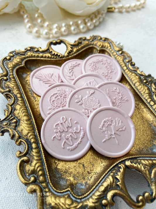 a bunch of pink buttons sitting on top of a tray