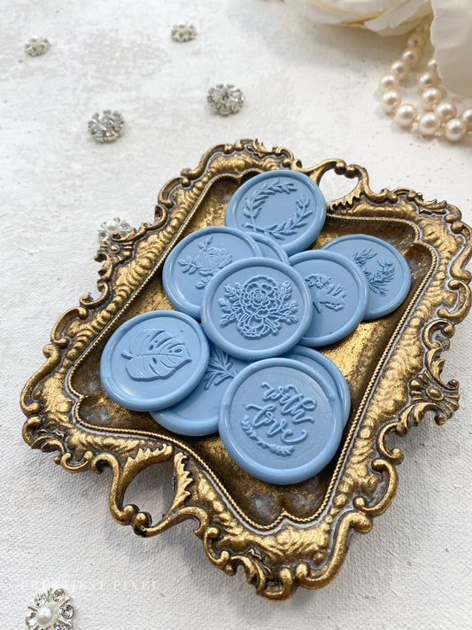 a group of blue buttons sitting on top of a metal tray