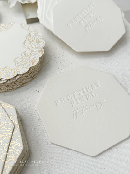 a table topped with white and gold coasters