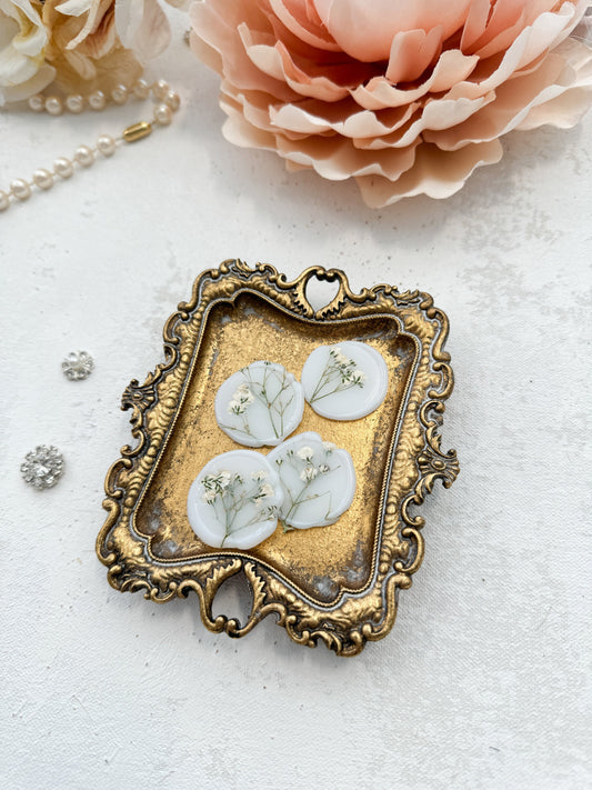 a picture frame with three white flowers on it