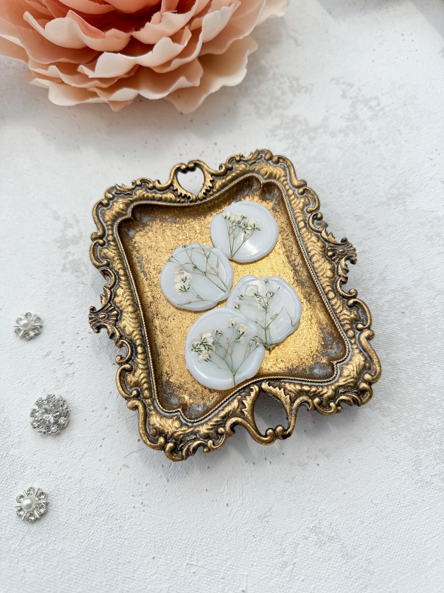 a picture of a brooch with a flower in the background